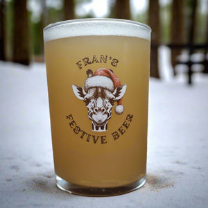 Personalised pint glass printed with a giraffe in a Santa hat and the text Daddy's Beer — custom Christmas glassware by First Class Design