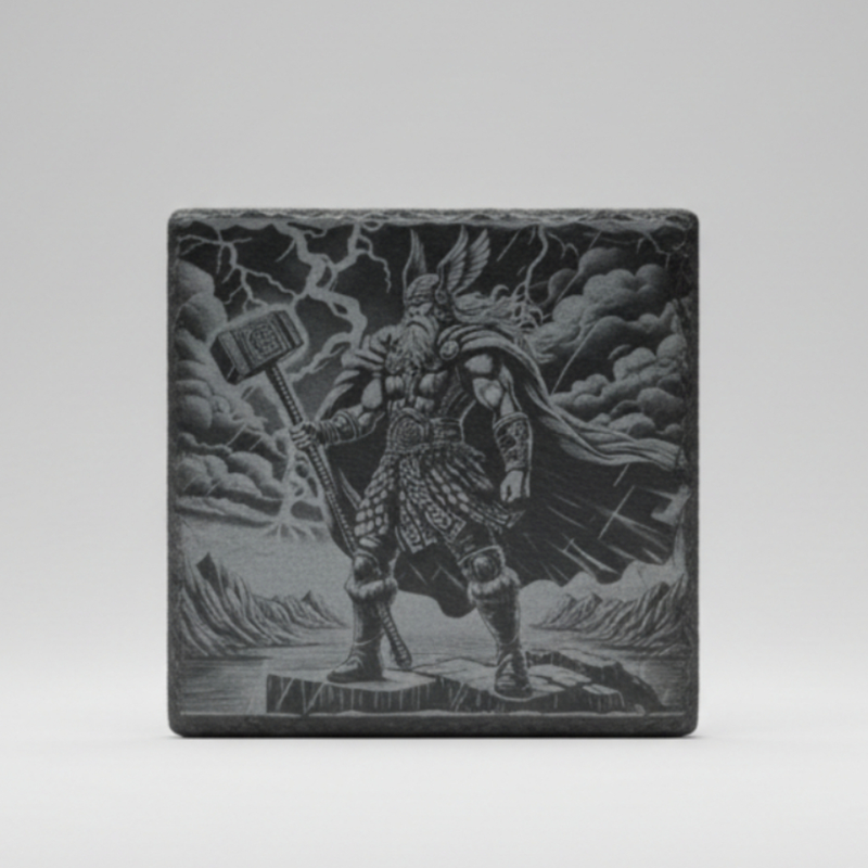 Slate coaster laser engraved with Thor wielding Mjolnir hammer, storm and mountain landscape, Norse mythology design