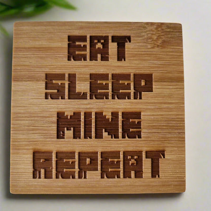 Laser engraved bamboo coaster with “Eat Sleep Mine Repeat” text – Minecraft-inspired eco-friendly gaming gift for kids, teens, and gamer décor