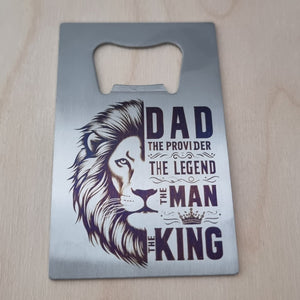 Metal bottle opener with lion design and text on a wooden surface