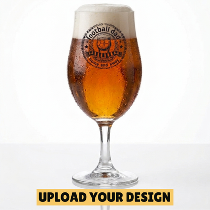 Personalised 568ml chalice pint glass with custom uploaded football dad home and away badge design filled with golden beer on marble surface