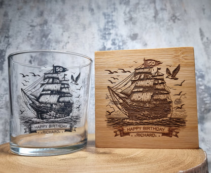Personalised rum glass with ship design, custom name and age, shown with optional bamboo coaster and varnished wooden gift box – nautical themed gift for him