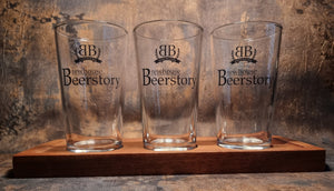 Personalised beer flight paddle set with three custom printed half pint glasses featuring YOUR LOGO HERE design on wooden serving board