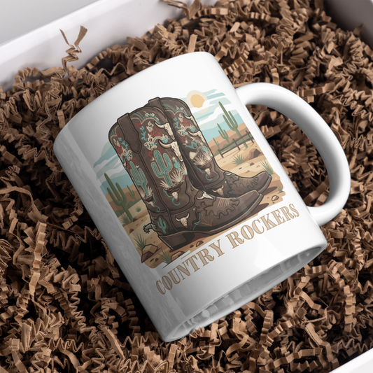 Personalised cowboy boots coffee mug with custom name engraving 
displayed in white gift box with brown kraft paper, ready for gift 
giving, featuring western desert landscape and ornate boot artwork