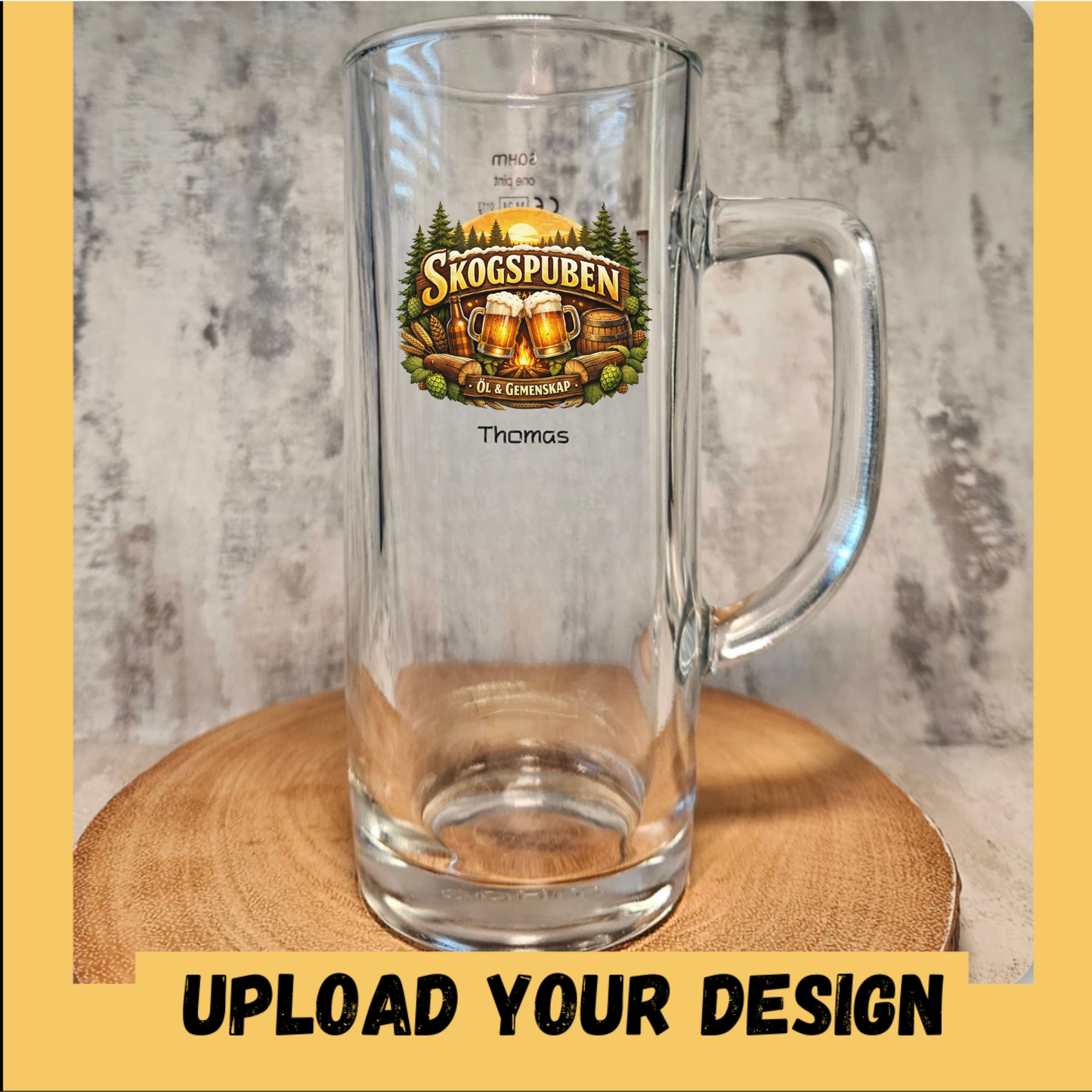 Personalised glass pint stein with handle printed with a custom craft beer logo design and personalised name below — example of uploaded design with text addon, shown on wooden slice