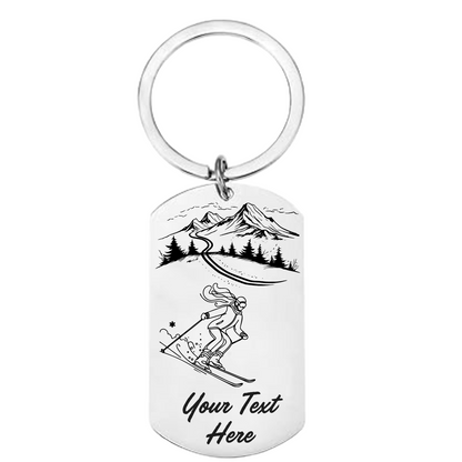 Keychain with mountain and skier design and customizable text on a white background