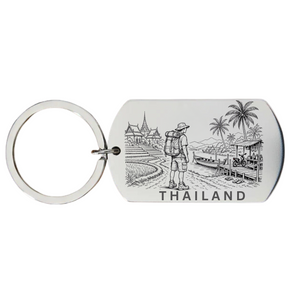 Thailand backpacker keyring laser engraved stainless steel dog tag with male backpacker temple palm trees and long-tail boat scene on white background