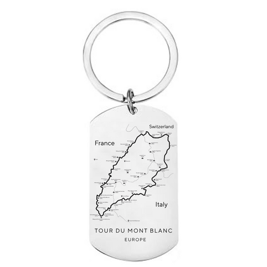 Tour du Mont Blanc route map laser engraved stainless steel dog tag keyring showing complete TMB circular trail through France Italy and Switzerland with refuges and cols on white background