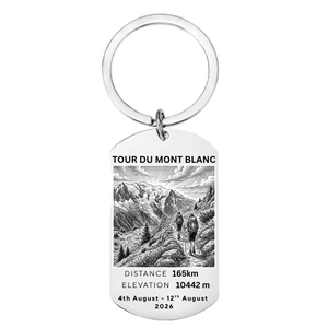 Tour du Mont Blanc laser engraved stainless steel dog tag keyring 
with mountain landscape illustration distance elevation stats and personalised dates on white background