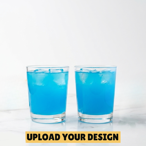 Two personalised 25ml shot glasses filled with blue cocktail on marble surface, unique custom printed party gift
