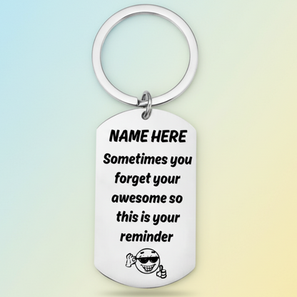 Personalised 'you're awesome' keyring with custom name placeholder, displaying the message 'Sometimes you forget your awesome so this is your reminder' with a smiling character wearing sunglasses