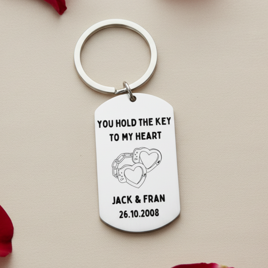 Keychain with 'You hold the key to my heart' text and heart handcuff design on a white background