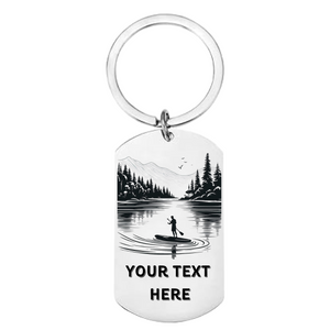 Close up of laser engraved mountain lake paddleboard scene on personalised stainless steel keyring showing female silhouette and custom text