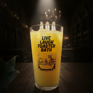 Clear drinking glass with “Live Laugh Toaster Bath” text and skeleton in bathtub with toaster – funny dark humour glass for goth, emo, or alternative gifts