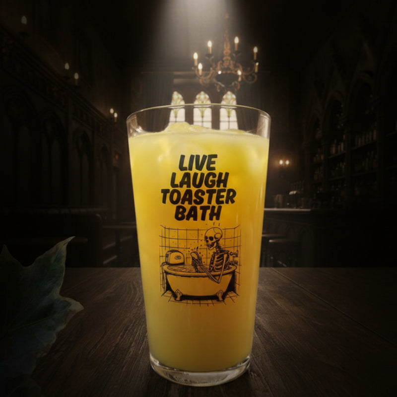 Clear drinking glass with “Live Laugh Toaster Bath” text and skeleton in bathtub with toaster – funny dark humour glass for goth, emo, or alternative gifts
