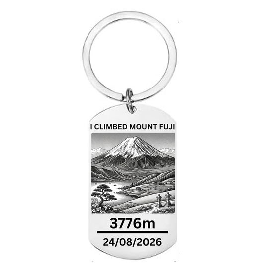I Climbed Mount Fuji laser engraved stainless steel dog tag keyring with Japanese landscape illustration cherry blossom pine tree stone lanterns and personalised climb date on white background