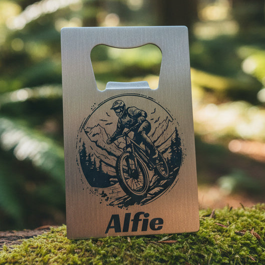 Metal bottle opener with a graphic of a person on a mountain trial bike and a personalised name