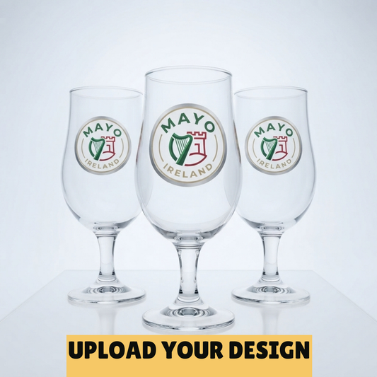 Three clear beer glasses with circular Mayo Ireland logos, shown on a light gray background with a yellow banner at the bottom reading 'UPLOAD YOUR DESIGN'.