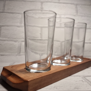 Close up of three custom printed personalised half pint glasses on wooden beer flight paddle, upload your own design gift