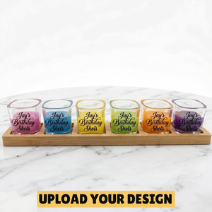 personalised set of six 60ml shot glasses on laser engraved bamboo paddle showing Jay's Birthday Shots design in rainbow coloured drinks on marble surface