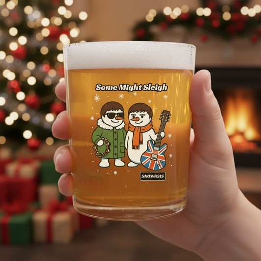 Glass of beer with snowmen holding a guitar and wreath, text 'Some Might Sleigh', and 'SNOWASIS' logo.
