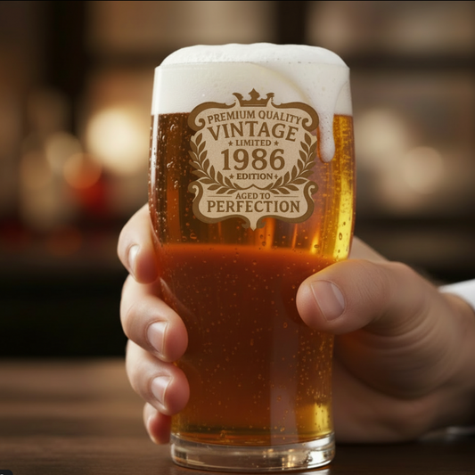 Close-up detail of laser-engraved birthday beer glass showing sharp 
"Aged to Perfection - [Year]" text with decorative vintage frame design 
on premium borosilicate glass